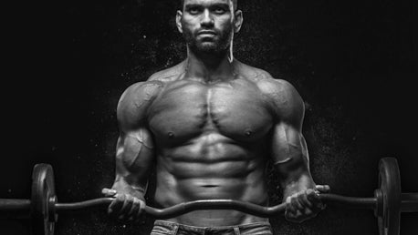 A Man Performing a Barbel Curl to Strengthen His Biceps